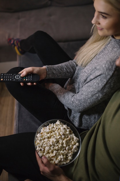 Foto gratuita pareja de cultivos viendo la televisión en el sofá