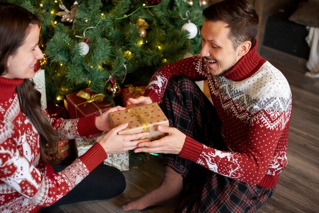 Pareja dándose regalos de Navidad