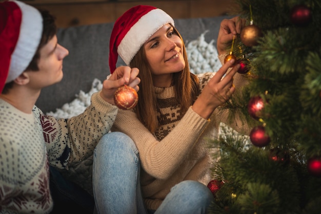 Pareja decorando el árbol de navidad