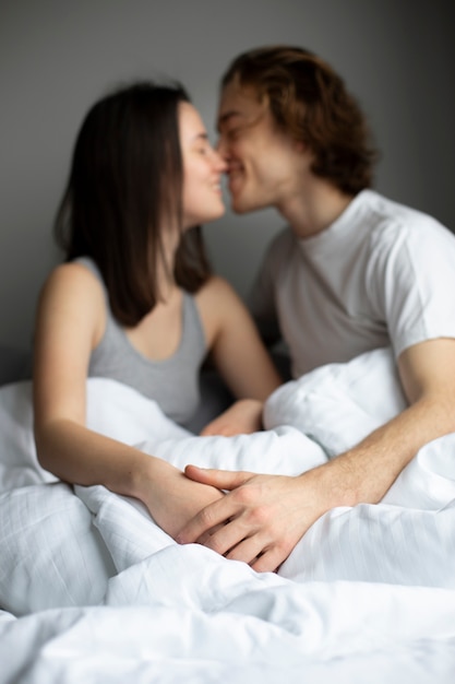 Pareja Defocused tomados de la mano y besándose