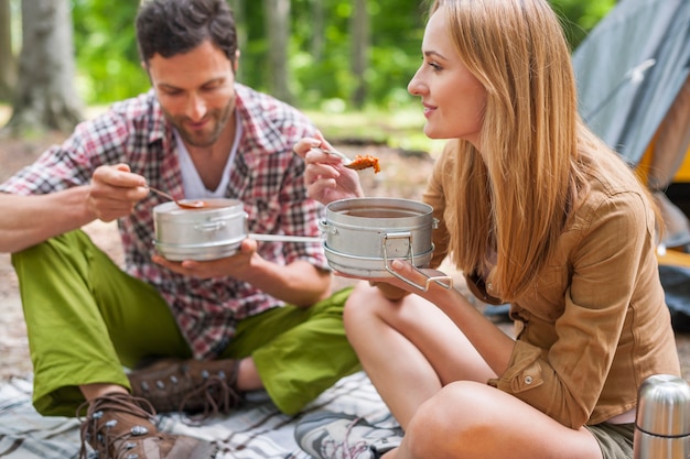 Pareja con una deliciosa cena en el camping.