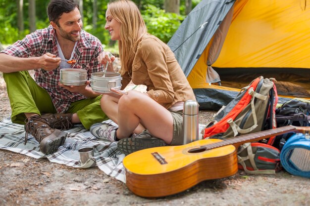 Pareja con una deliciosa cena en el camping.