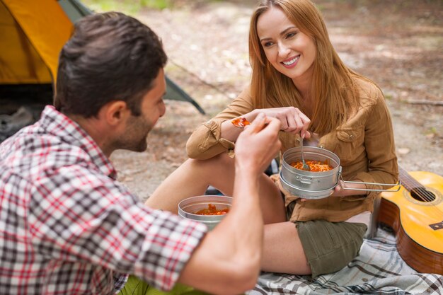 Pareja con una deliciosa cena en el camping.