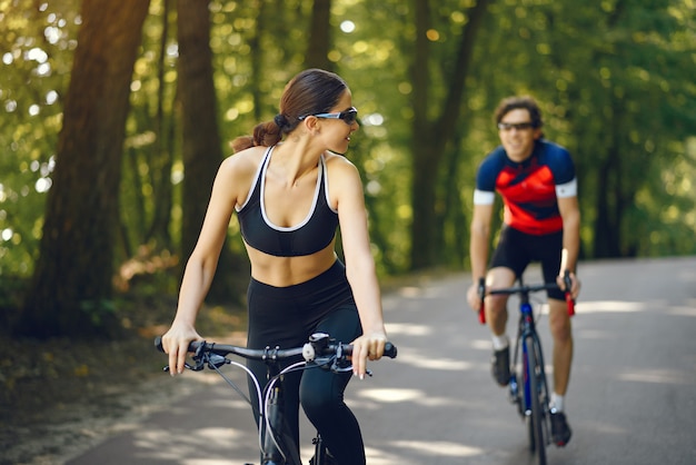 Pareja deportiva andar en bicicleta en el bosque de verano