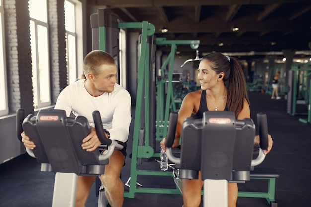 Foto gratuita pareja deportiva en un entrenamiento de ropa deportiva en un gimnasio