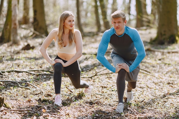 Pareja deportiva entrenando en un bosque de verano