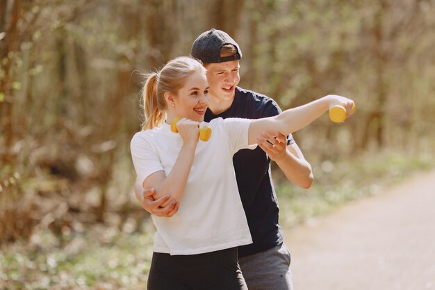 Pareja deportiva entrenando en un bosque de verano