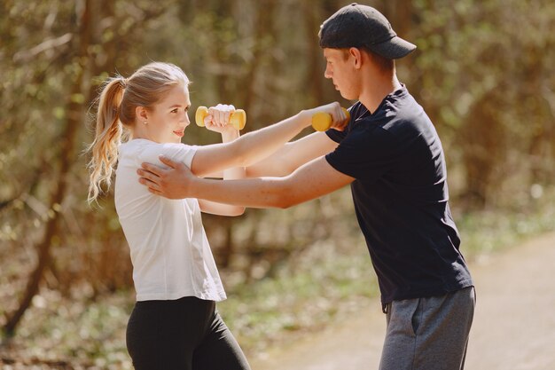 Pareja deportiva entrenando en un bosque de verano