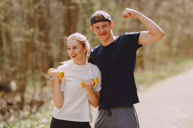 Pareja deportiva entrenando en un bosque de verano