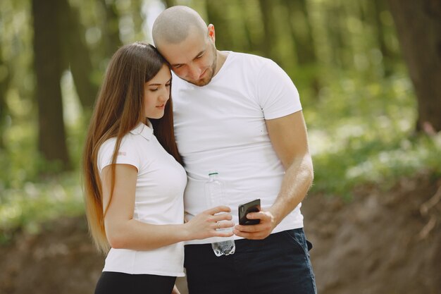 Pareja deportiva pasa tiempo en un bosque de verano