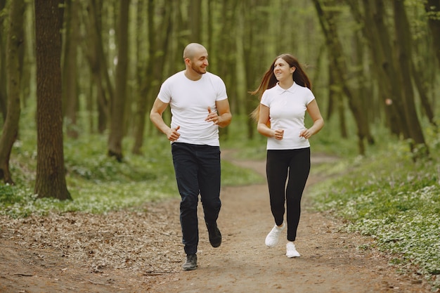 Pareja deportiva pasa tiempo en un bosque de verano