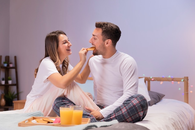 Pareja desayunando en la cama