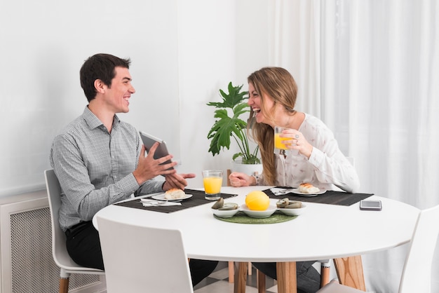 Foto gratuita pareja desayunando y hablando en casa