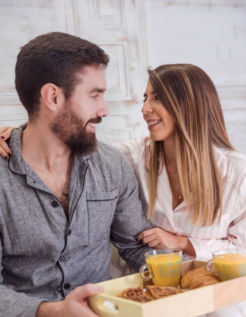 Pareja con desayuno en bandeja de madera