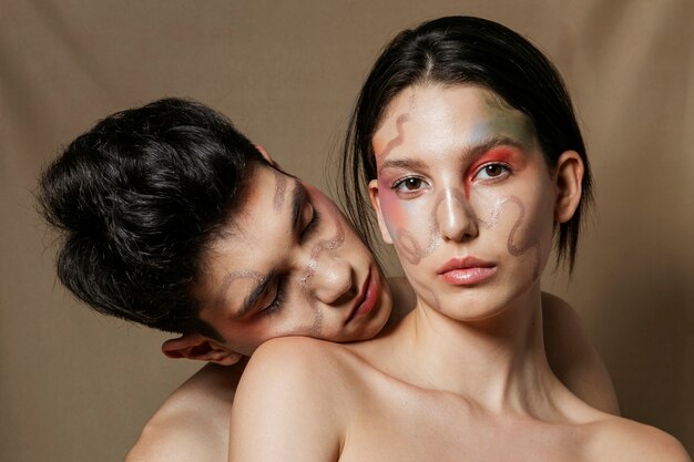 Pareja desnuda posando con caras pintadas