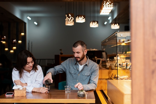 Foto gratuita pareja disfrutando de café en la tienda