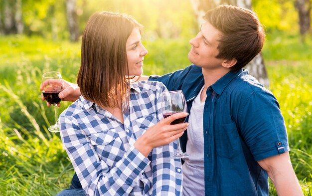 Pareja disfrutando mutuamente sentados en el bosque