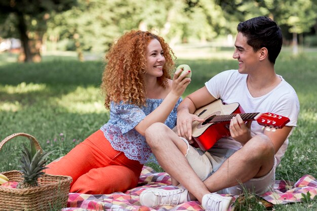 Pareja disfrutando de picnic en el parque