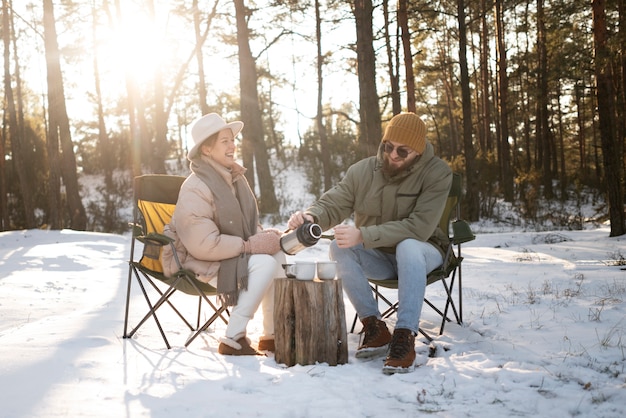 Pareja disfrutando de su campamento de invierno