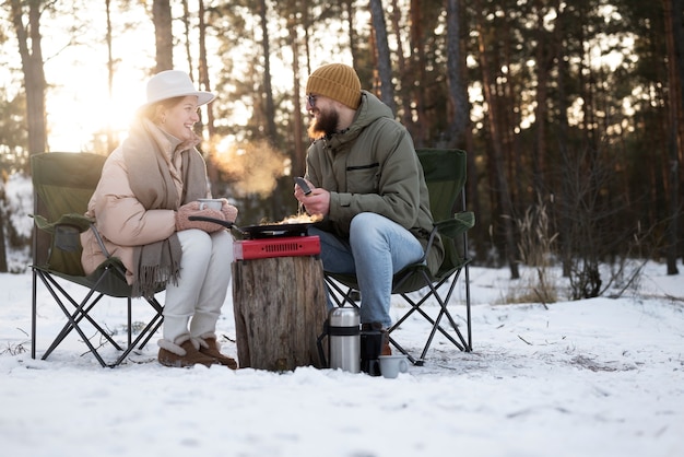 Pareja disfrutando de su campamento de invierno