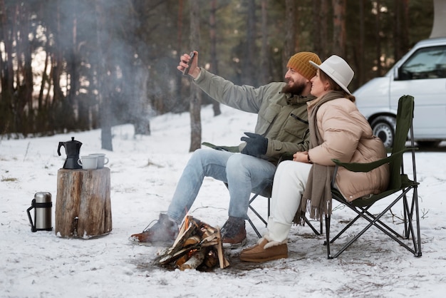 Foto gratuita pareja disfrutando de su campamento de invierno