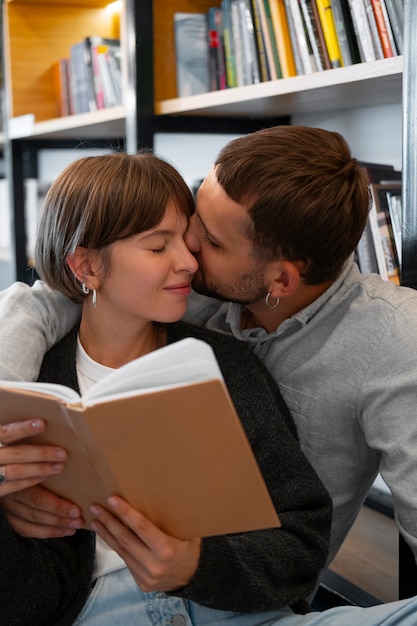 Foto gratuita pareja disfrutando de su cita en la librería