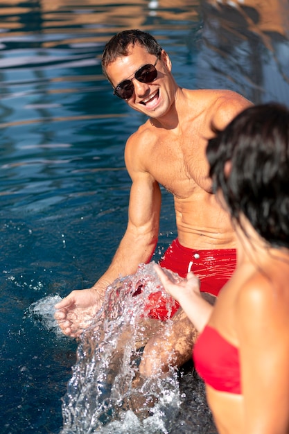 Foto gratuita pareja disfrutando de su día en la piscina