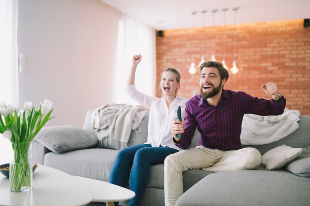 Pareja disfrutando de TV en el sofá