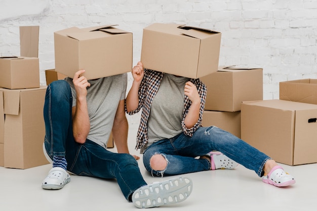 Foto gratuita pareja divertida con cajas en las cabezas