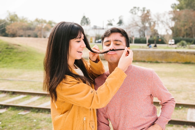 Foto gratuita pareja divertida engañando cerca de rieles