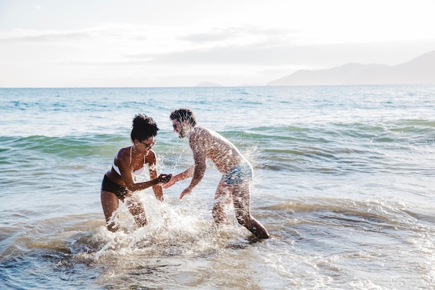 Foto gratuita pareja divirtiéndose en el agua en la playa