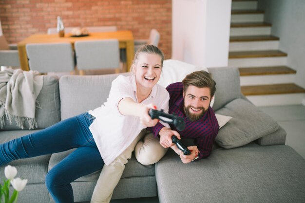 Pareja divirtiéndose y jugando consola