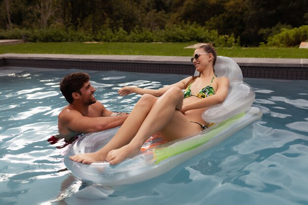 Pareja divirtiéndose juntos en la piscina