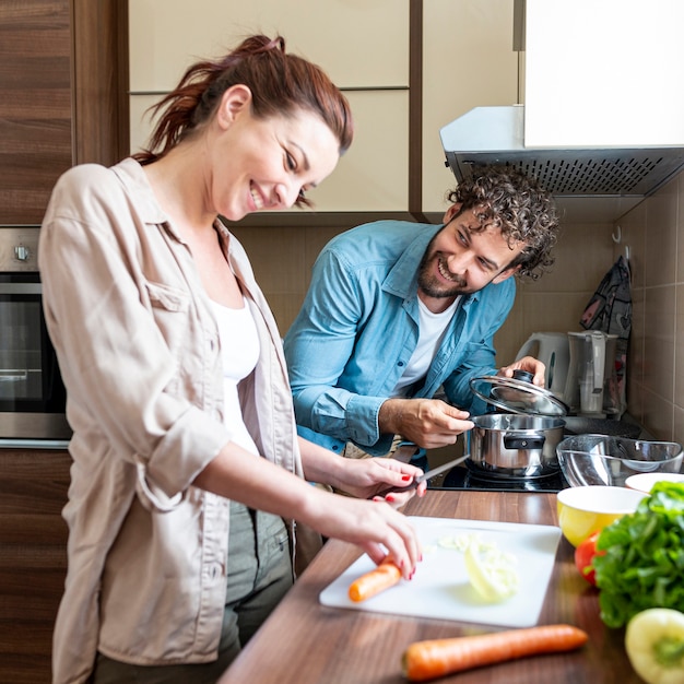 Foto gratuita pareja divirtiéndose mientras prepara la cena