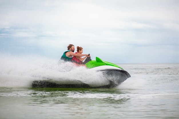 Pareja divirtiéndose en moto de agua actividad de mar de verano