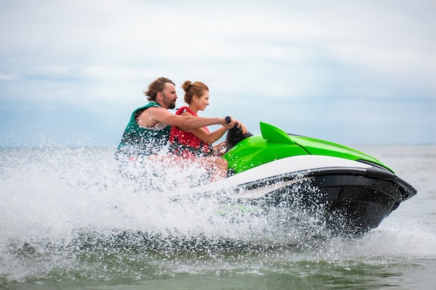 Pareja divirtiéndose en moto de agua actividad de mar de verano