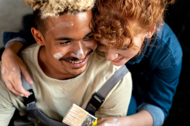 Foto gratuita pareja divirtiéndose con pincel en su nuevo hogar