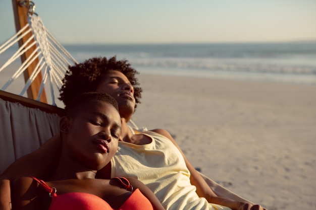 Pareja durmiendo en una hamaca en la playa