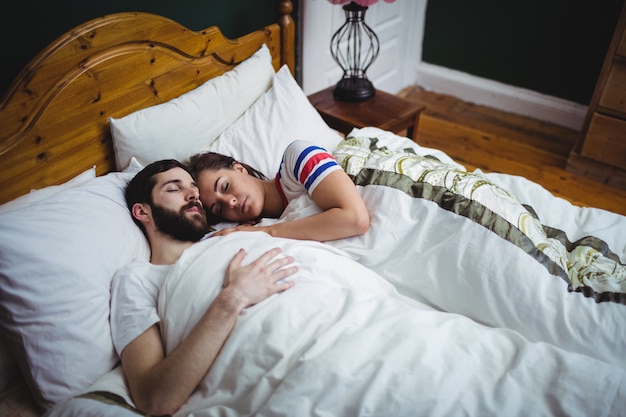 Pareja durmiendo juntos en la cama