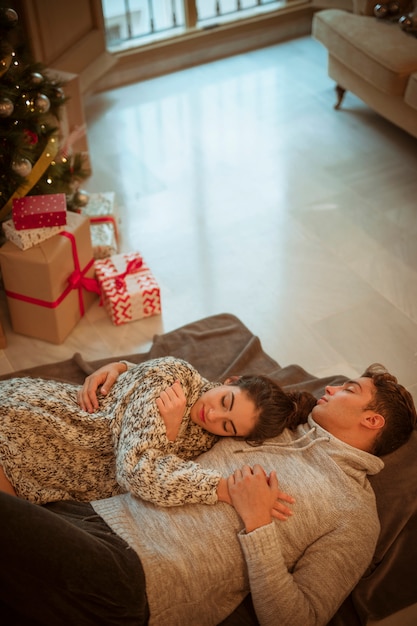 Foto gratuita pareja durmiendo en el piso en regalos