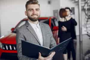 Foto gratuita pareja elegante y elegante en el salón del automóvil.