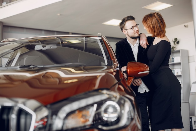 Pareja elegante y elegante en el salón del automóvil.