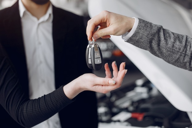 Pareja elegante y elegante en un salón de autos.