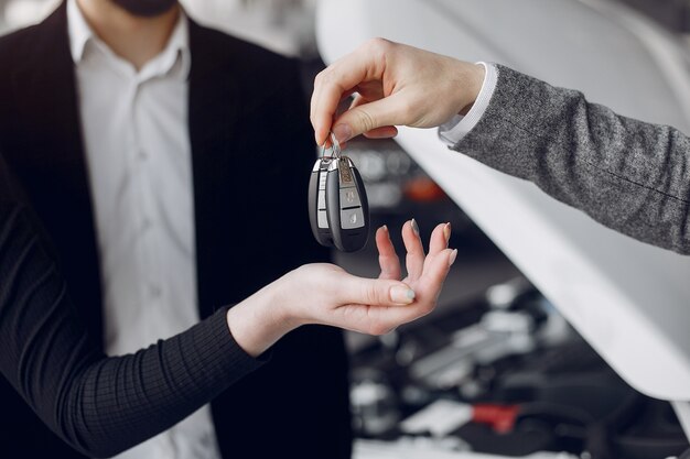 Pareja elegante y elegante en un salón de autos.