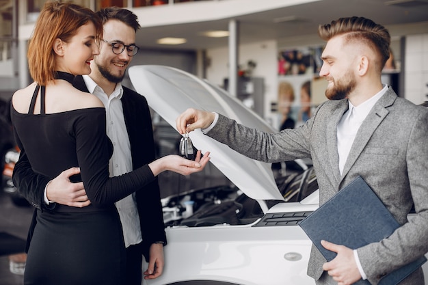 Pareja elegante y elegante en un salón de autos.