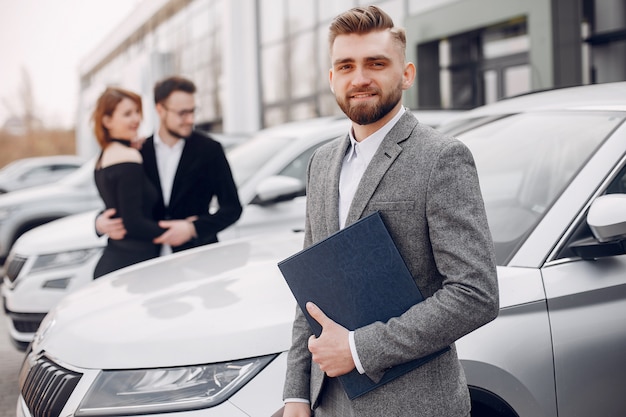 Pareja elegante y elegante en un salón de autos.