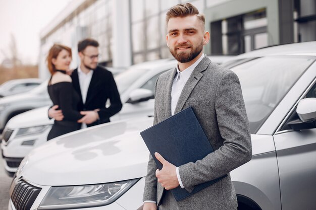 Pareja elegante y elegante en un salón de autos.