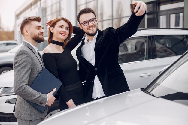 Pareja elegante y elegante en un salón de autos.