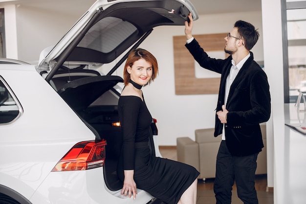 Pareja elegante y elegante en un salón de autos.