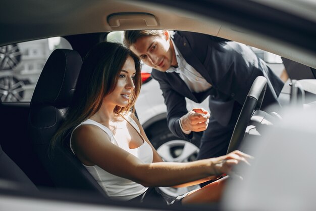 Pareja elegante y elegante en un salón de autos